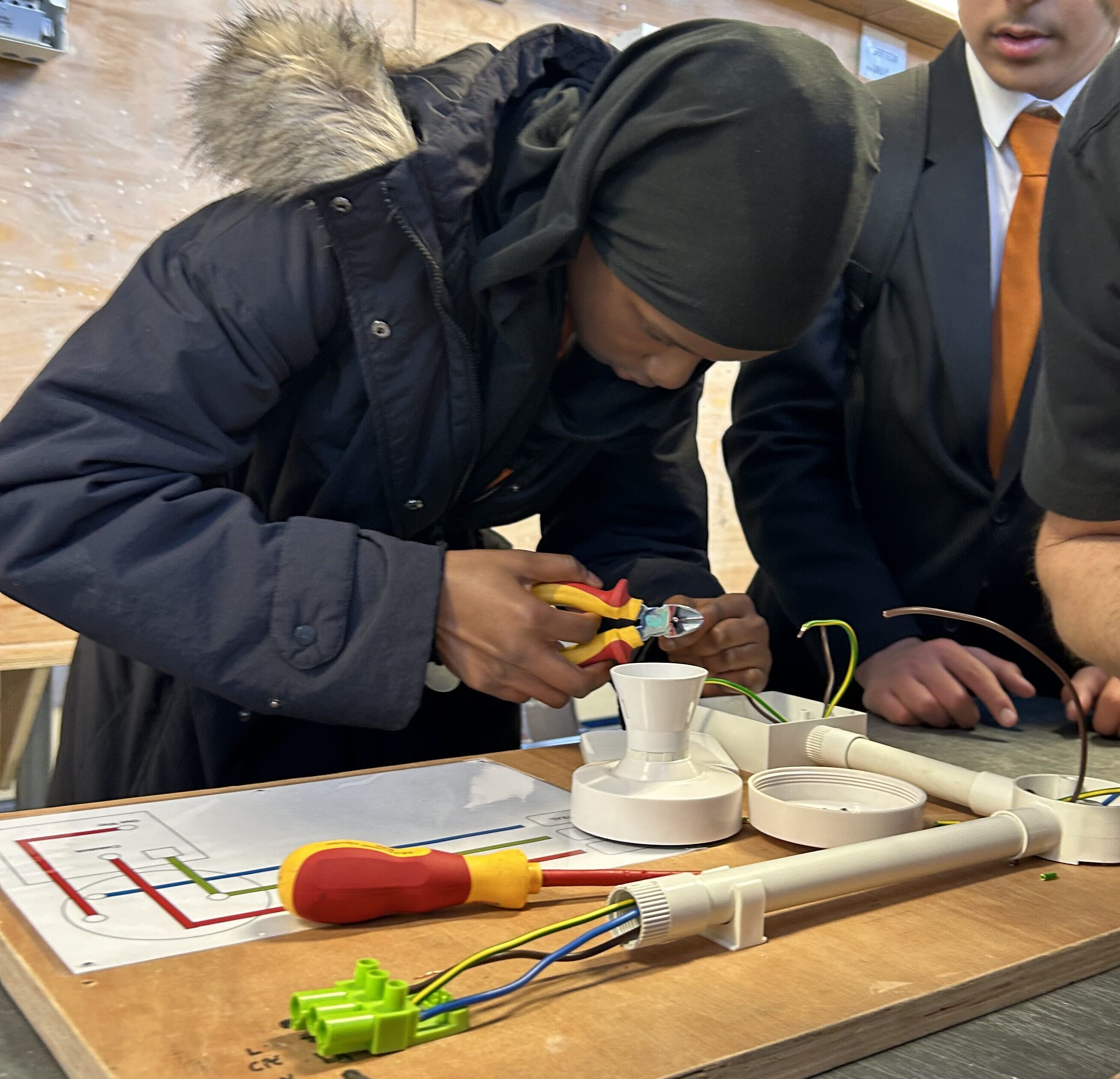A student from Co-op Academy Leeds taking part in an employer-supervised electronics activity at a workbench